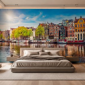 Mavi gökyüzü ve kanal suları arasında yükselen Amsterdam mimarisi temalı duvar kağıdı; geniş krem karyola, asma ahşap komodinler ve gizli tavan LED ışığıyla ebeveyn yatak odalarında davetkar bir ortam oluşturur.