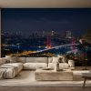 Kırmızı ışıklarıyla parlayan İstanbul Boğaz Köprüsü ve şehir manzarası; geniş krem L koltuk, traverten orta sehpa ve balıksırtı parkeyle salona modern ve prestijli bir dokunuş kazandırır.