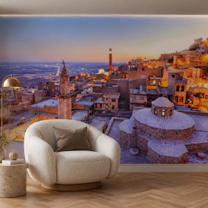 Tarihi Mardin taş mimarisi, kubbe ve minare görünümü; krem döner berjer, pirinç gövdeli lambader ve traverten yan sehpayla okuma ve dinlenme köşelerine sıcak bir ortam kazandırır.