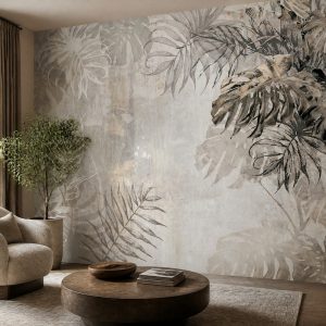 Beton ve mermer efektli açık bej/gri zemin üzerine siyah, koyu gri ve vizon tonlarında çizim tropical deve tabanı ve palmiye yaprakları motifli duvar kağıdı; krem berjer, ahşap yuvarlak orta sehpa ve saksı bitkisiyle mekana modern ve şık bir hava katar.