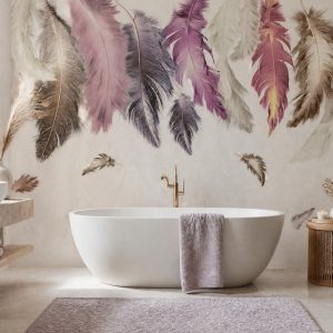 Nötr krem fon üzerine tavandan aşağıya doğru uzanan sulu boya tüy detaylı duvar kağıdı; modern oval beyaz küvet, pembe banyo paspası ve pirinç bataryayla banyolara şık bir spa ferahlığı katar.