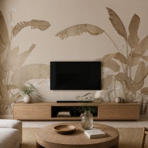 Soft bej arka plan üzerinde uzanan taba ve vizon renkli tropikal muz yaprakları illüstrasyonlu duvar kağıdı; duvara monte TV, ahşap TV konsolu ve ahşap orta sehpayla salona ferah, modern ve doğal bir atmosfer katar.