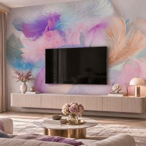Canlı mor, pembe, turkuaz ve lila tonlarında katmanlı tüyler ve renk dalgaları temalı duvar kağıdı; duvara monte televizyon, oluklu açık renk TV ünitesi konsolu, mermer orta sehpa ve pembe çiçeklerle salonlarda göz alıcı bir TV arkası dekorasyonu oluşturur.