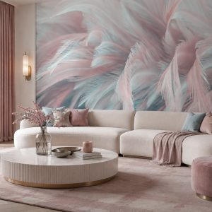 Pudra pembe, pastel mavi ve gri tonlarında makro tüy efektli duvar kağıdı; geniş krem kavisli modüler L koltuk takımı, yuvarlak mermer orta sehpa ve soft pembe halıyla salona modern, ferah ve davetkar bir hava katar.
