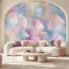 Soft pastel tonlarda rüya gibi tüy ve renk dalgaları temalı duvar kağıdı; krem kavisli modüler kanepe, traverten taş orta sehpa, dairesel mimari kemer ve renkli kırlentlerle salona ferah, modern ve masalsı bir dokunuş kazandırır.