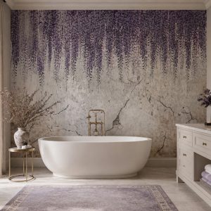 Eskitme dokulu nötr zemin üzerine sarkan mor wisteria çiçekleri duvar kağıdı; standalone oval beyaz küvet, krem banyo dolabı ve mor halıyla banyo alanlarına lüks bir spa dinginliği katar.
