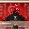 Kırmızı zemin üzerinde Türk bayrağı dalgalandıran halk silüeti, "15 Temmuz Destanı" logosu, Orhan Şaik Gökyay'ın "Bu Vatan Kimin?" ve Arif Nihat Asya'nın "Bayrak" şiirleri çerçevelerinin yer aldığı; her iki yanında pirinç direkli Türk bayrakları ve mermer zeminli protokolle uyumlu dev duvar kağıdı kaplaması.