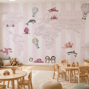 Pembe ve beyaz dikey çizgiler üzerinde dünya haritası, uçan balonlar ve hayvan illüstrasyonları içeren duvar kağıdı; ahşap yuvarlak çocuk masası, sandalyeler ve natürel halıyla döşenmiş geniş oyun alanı.
