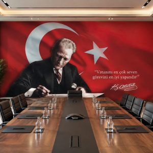 Uzun masif ahşap toplantı masası ve siyah deri koltukların arkasında uygulanan, kırmızı Türk bayrağı ve ay-yıldızlı fon üzerinde Atatürk portresi ile vecizesini içeren kurumsal toplantı salonu duvar kağıdı kaplaması.
